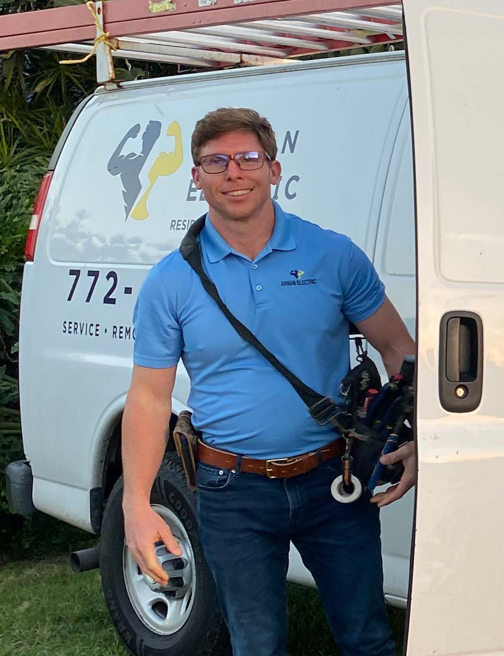 Sean VanArman, owner of Arman Electric, beside the company van