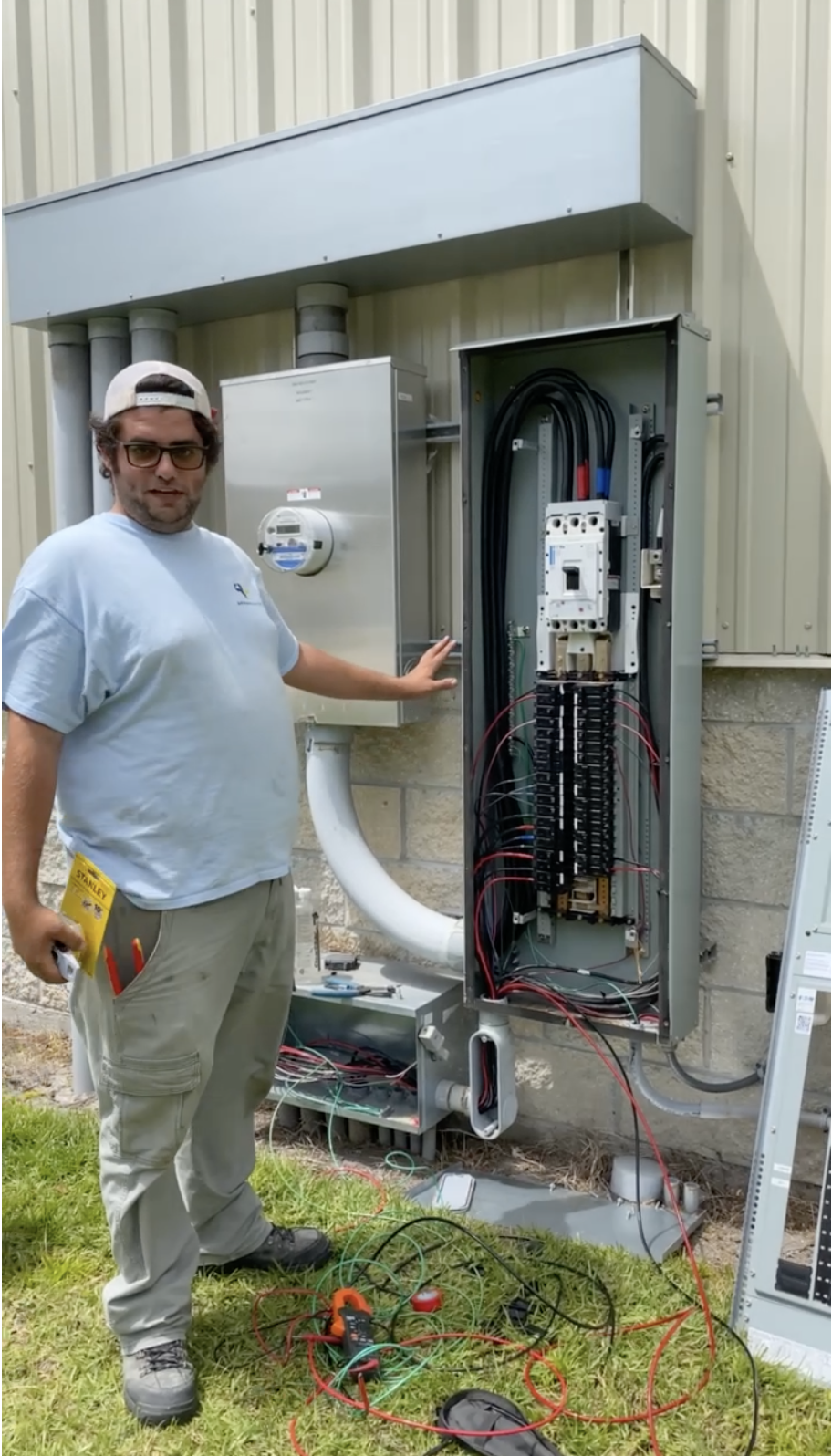 Electrician working on an outdoor electrical panel and meter