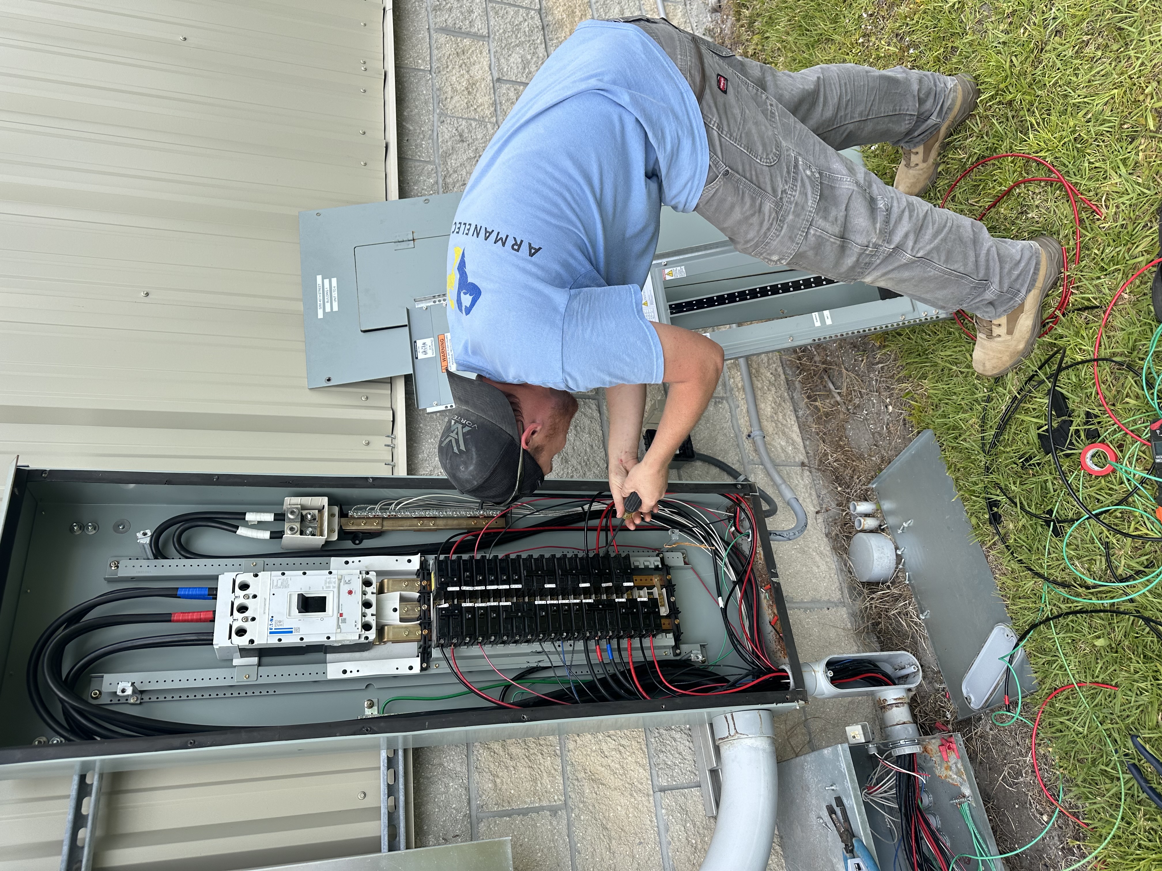Electrician working inside an exterior electrical panel
